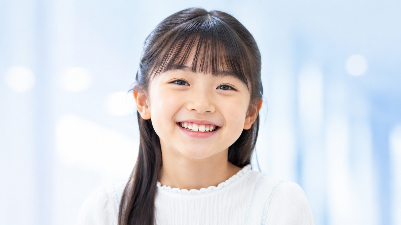 歯科医師が子どもと保護者へ小児矯正について説明している様子