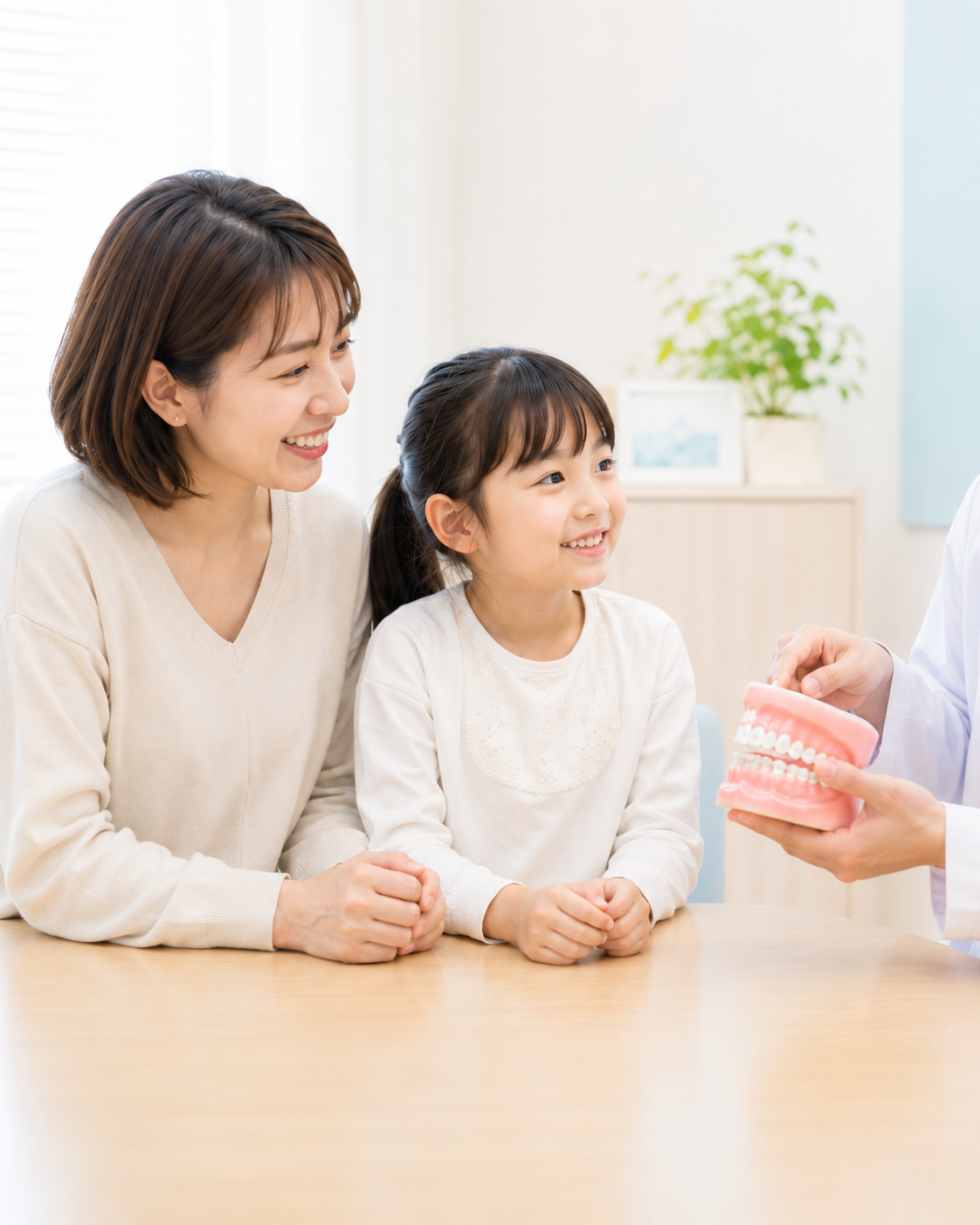 歯科医師がお子様と保護者へ矯正治療について説明している様子